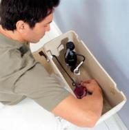 Plumber in Brighton, CO opens a tank to inspect a toilet